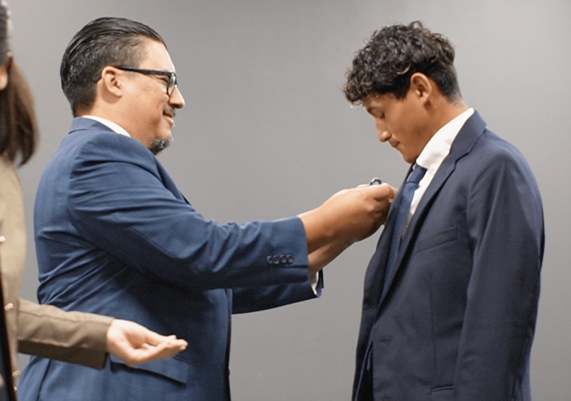 Male-student-receiving-lapel-pin-1 Male-student-receiving-lapel-pin-1